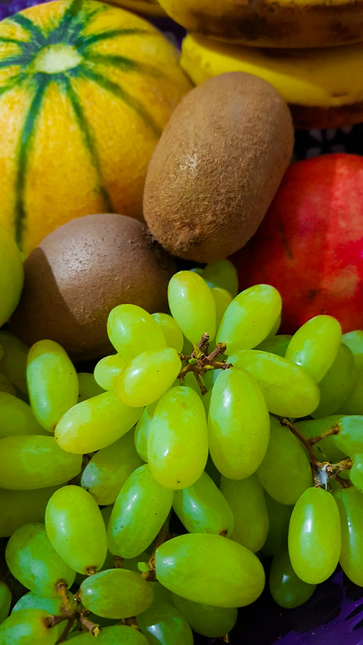 green and brown fruits on white surface