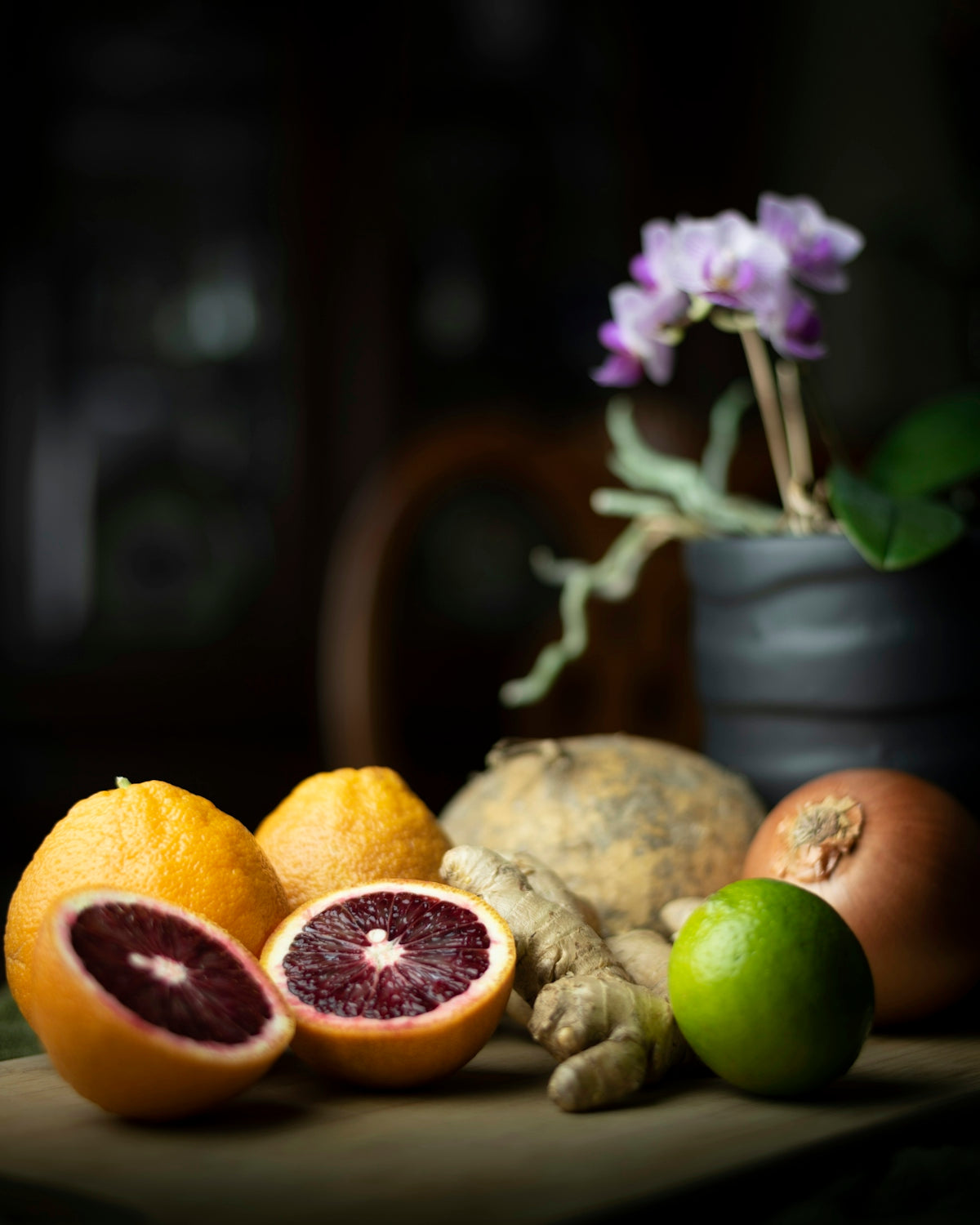 a table topped with fruits and vegetables next to a potted plant