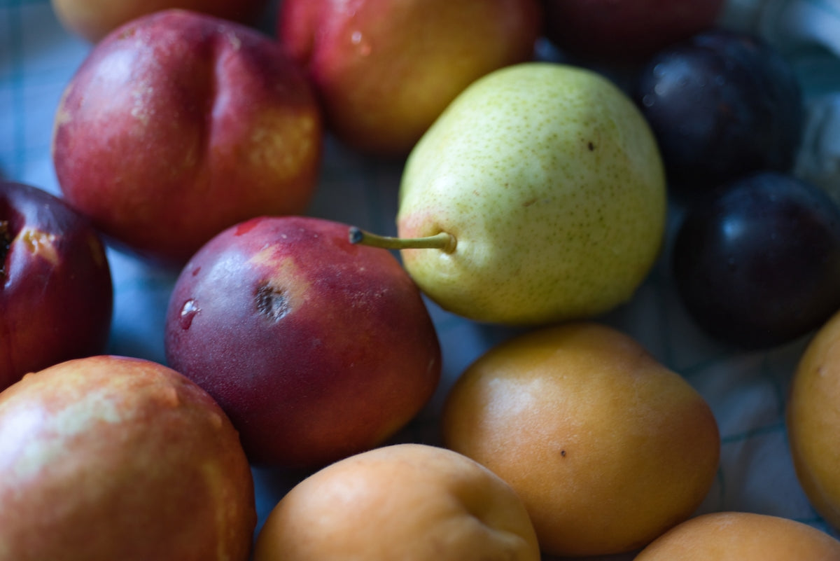 Various types of fresh, ripe fruit are piled together.